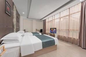 Une chambre d’hôtel avec deux lits, une télévision et une grande fenêtre avec des rideaux légers.