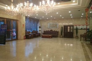 A spacious lobby with a chandelier, seating area, and a reception desk. - Lanyi Holiday Hotel (Kelan)
