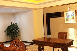 Una habitación con una mesa de comedor de madera, una planta en maceta y un cuadro en la pared.
