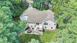 A two-story house with a covered front porch, a small deck, and a staircase leading to the second floor.