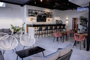 A modern bar area with a counter, seating arrangements, and a sign for 'caffe' BORBONE.