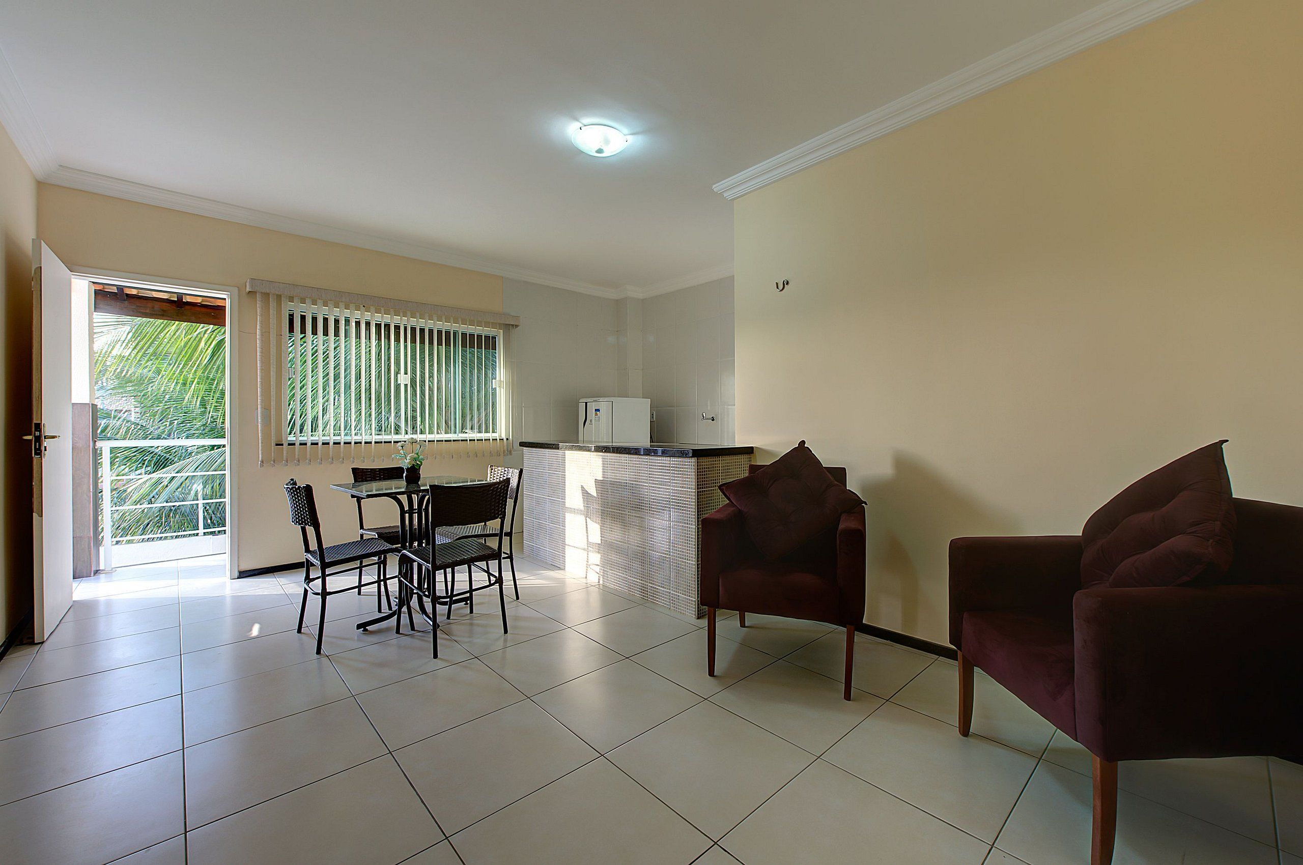 Un amplio espacio habitable con una mesa de comedor, dos sillas, un sofá y un refrigerador.