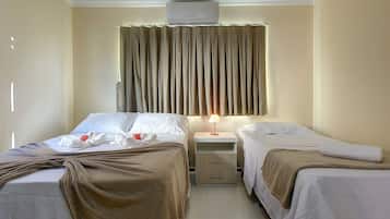 Une chambre d’hôtel avec deux lits, une table de chevet, une lampe et un appareil de climatisation.