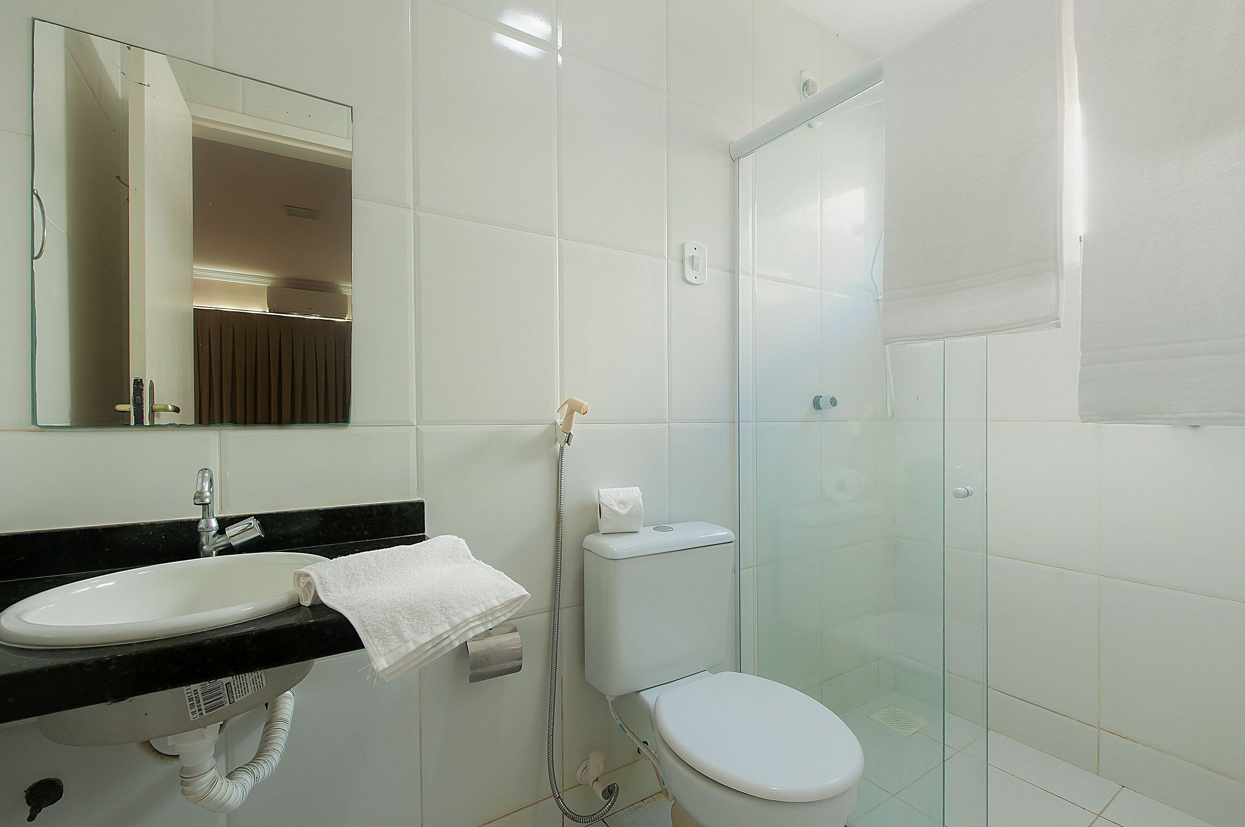 A bathroom with a sink, toilet, and glass shower enclosure.