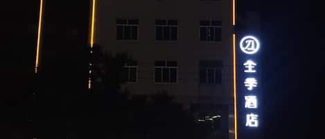 A hotel building with illuminated signage and a flag on top.