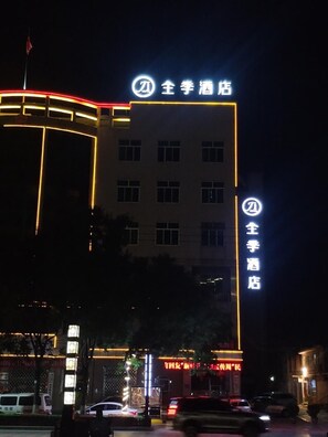 A hotel building with illuminated signage and a flag on top.