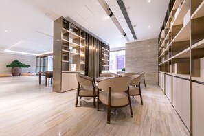 A modern dining area with a round table, chairs, and built-in shelving. - Ji Hotel (Tongchuan)