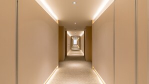 A long, narrow hallway with a carpeted floor and light-colored walls. - Ji Hotel (Tongchuan)