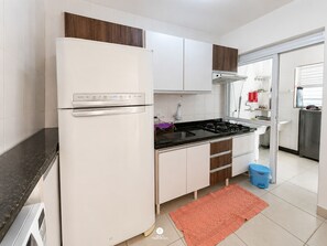 A modern kitchen with a built-in refrigerator, stove, and white cabinetry. - Nautilus Ap Club Premium - Penha-SC (Penha)