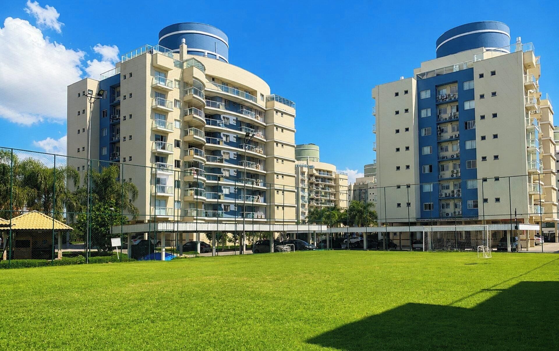 A modern apartment building with multiple balconies and a flat roof.