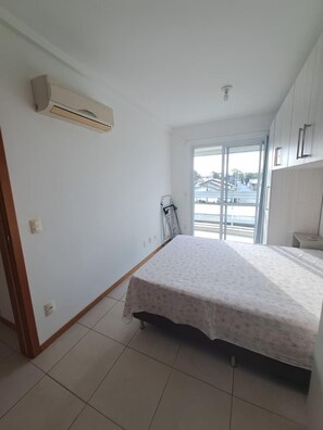 Un dormitorio con cama, ventana y puerta.
