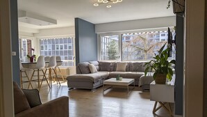 Un salon moderne comprenant un canapé, une table basse et un coin repas avec des chaises et une table.