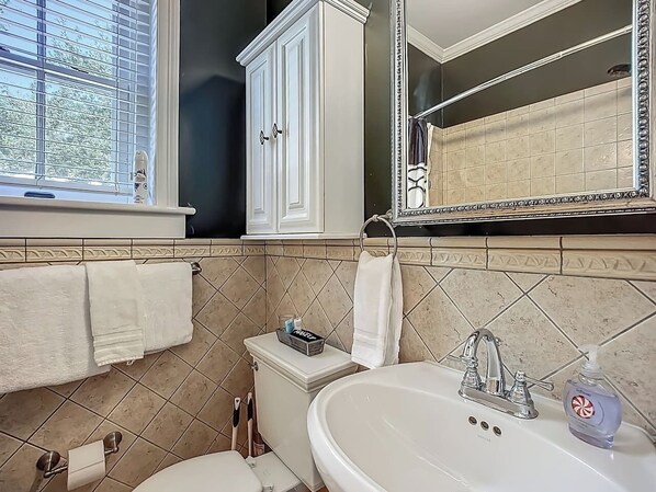 A bathroom with a toilet, sink, and cabinet.