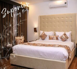 A King Bed with a tufted headboard, white bedding, and patterned pillows. - Grand Mongolia Hotel (Rawalpindi)