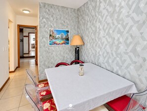 A hotel room with a dining area featuring a table, chairs, and a lamp. - Nautilus Paradise in Penha-SC (Penha)
