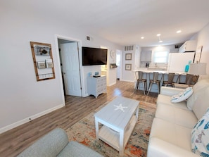 Relax in this open-plan living space with a sofa, armchair, and coffee table.