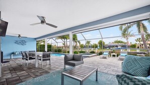 Ein moderner Außenbereich mit Pool, Sitzgelegenheiten und Deckenventilator.
