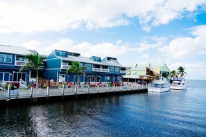 Ein Hotel am Wasser mit einer Anlegestelle, einem Boot namens 'Island Star' und einer Mole mit Personen.