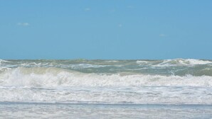 Une plage avec des vagues et un ciel dégagé.
