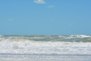 Une plage avec des vagues et un ciel dégagé.