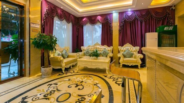 A luxurious lobby with ornate furniture, a grand chandelier, and a marble floor.