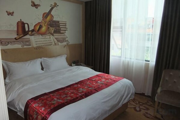 Una habitación de hotel con una cama, una mesita de noche, una silla y una ventana con cortinas.
