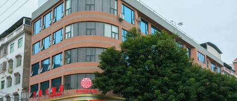 A multi-story hotel with a curved facade, large windows, and a prominent entrance with signage.