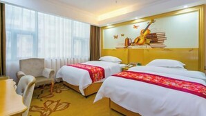 A hotel room with two beds, a chair, a desk, and a large window.