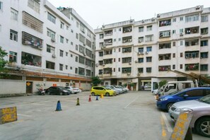A multi-story residential building with a parking area in front. - Wanxiang Hotel (Qinzhou Lingshan) (Lingshan)