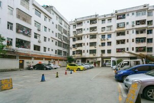 Un edificio residencial de varios pisos con una zona de estacionamiento al frente.