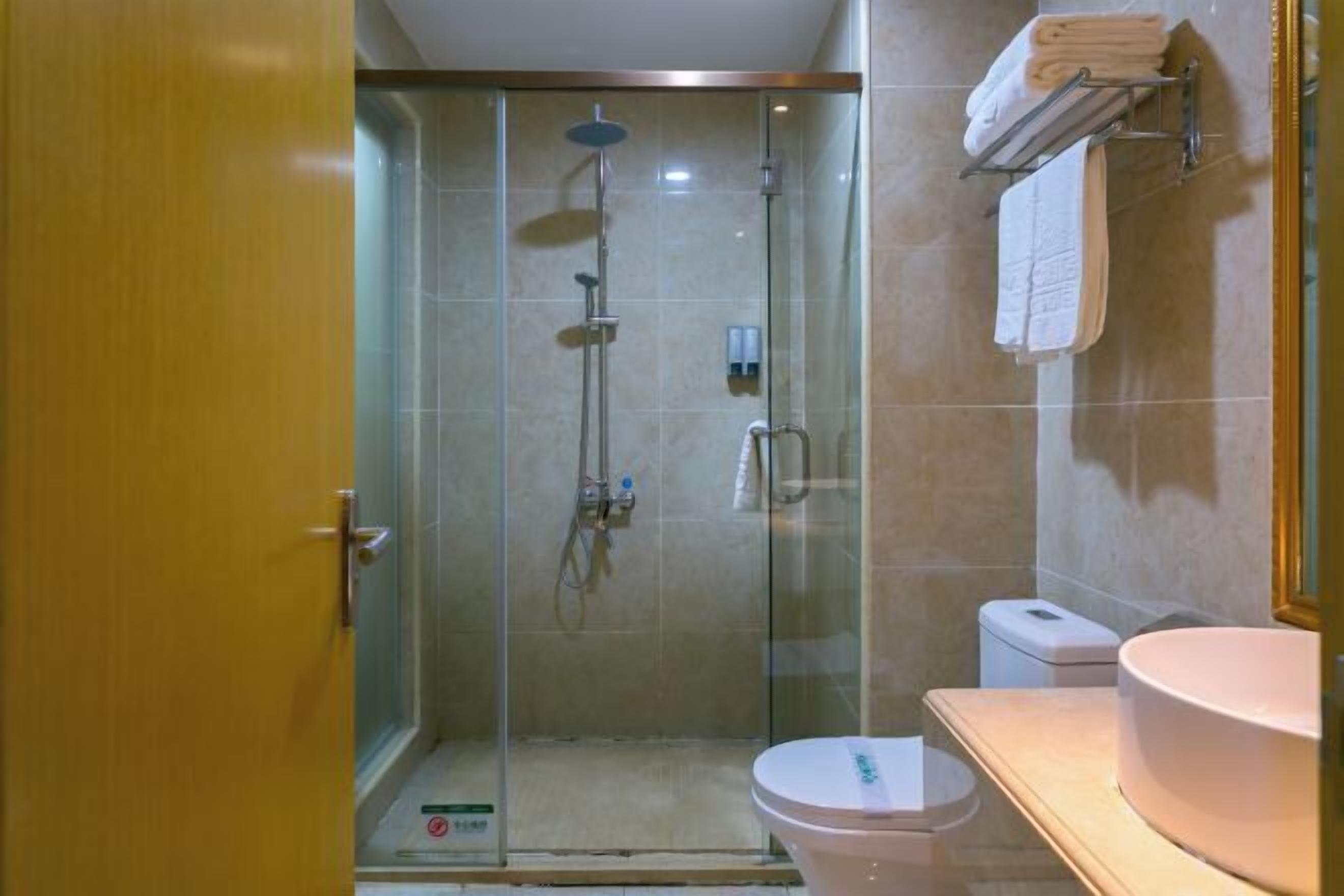 Un área de ducha con paredes de vidrio, un inodoro y un lavabo.