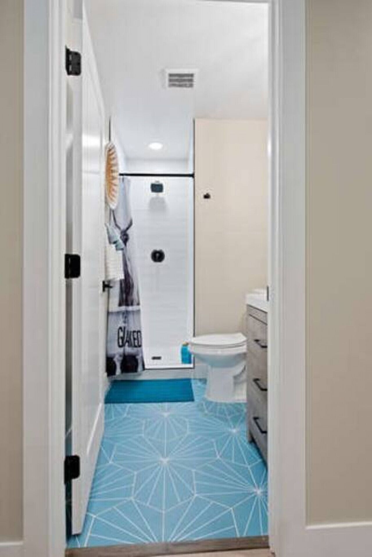 A bathroom with a toilet, a sink, and a shower area.