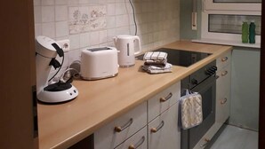 A kitchen with a wooden countertop, a built-in oven, a range hood, and a window with blinds. - Large bright vacation apartment_only for private guests_ no fitters (St. Leon-Rot)