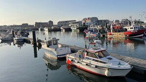 A marina with various boats docked, calm water, and buildings in the background. - Villa quai du Treport 4* facing port and sea. (Le treport)