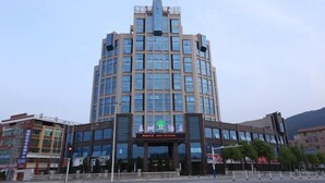 Et moderne hotel med et centralt atrium, flere etager og en markant indgang.