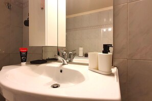 A hotel bathroom with a sink, mirror, and toiletries. - Vacation Home For 4 - ENTIRE FLAT (Athina)