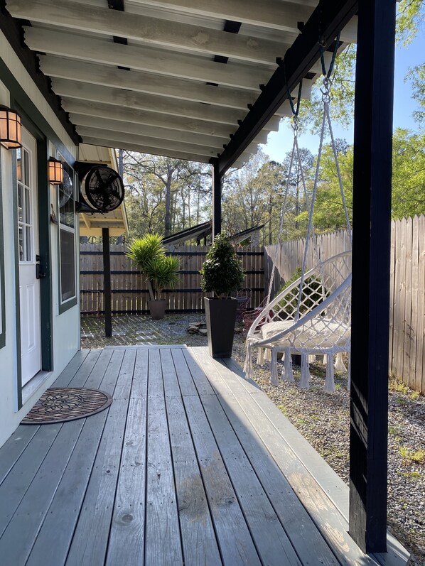 A wooden deck with a pergola, a potted plant, and a hammock. - Contemporary Cottage in the heart of Mandeville (Mandeville)