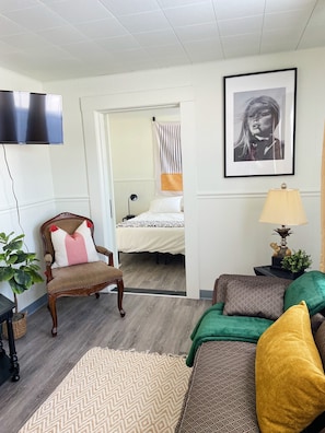 A modern living room with a sofa, a chair, a bed, and a TV. - Suite 104 | 2 Bed / 2 Bath + Living & Kitchen, Charming Sault Ste. Marie Suite (Sault Ste. Marie)