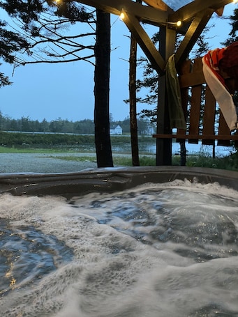 Outdoor spa tub. Lakefront country cabin with rustic charm overlooking lake