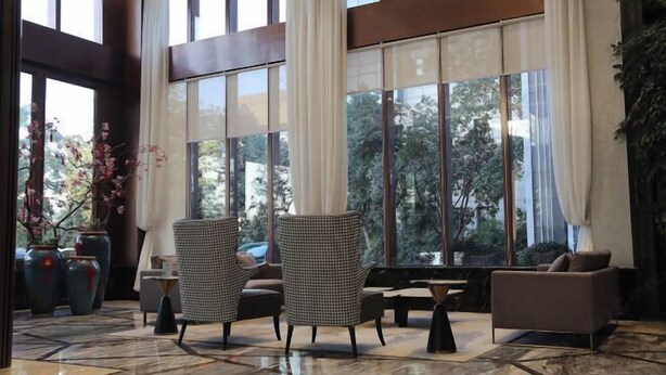 A spacious lobby with large windows, a piano, and seating arrangements. - Hangzhou Fuyang Blue Diamond International Castle Hotel (Hangzhou)