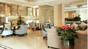 A spacious living area with a modern design, featuring a dining table and multiple seating options. - Hangzhou Fuyang Blue Diamond International Castle Hotel (Hangzhou)