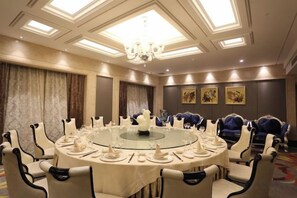 A conference room with a round table, chairs, and a chandelier. - Hangzhou Fuyang Blue Diamond International Castle Hotel (Hangzhou)