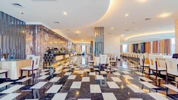 A hotel lobby with a checkered floor, a reception desk, and rows of seating.