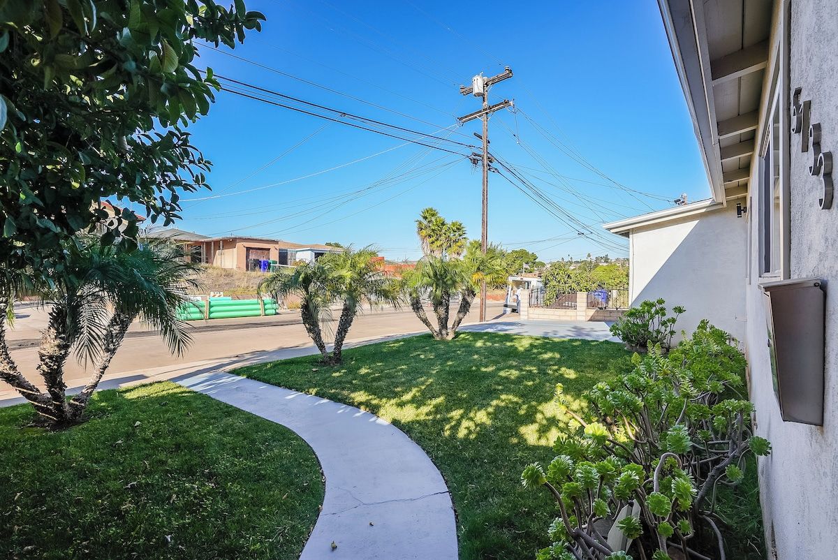 A residential area with a sidewalk, a street, and utility poles.