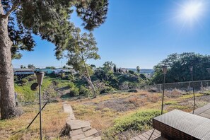 A pathway leading to a seating area with a view of a hilly landscape and buildings in the distance. - Canyon-View 4BR Home with Hot Tub & Fire Pit, 15 Min to Downtown (San Diego)