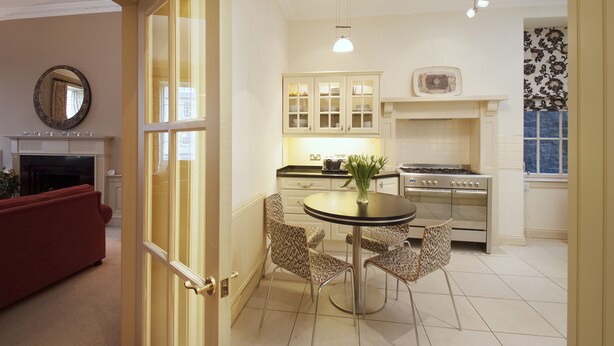 A modern kitchen with a dining table, chairs, and a stove. - Luxury central Edinburgh with stunning views of castle! (Edinburgh)