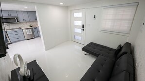 Una cocina moderna con armarios grises, microondas y encimera negra.