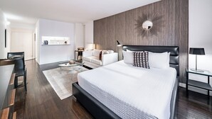 Una habitación de hotel moderna con una cama grande, un sofá, un escritorio y un espejo en la pared.