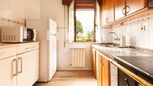 A kitchen with white cabinets, a microwave, a refrigerator, a window with curtains, and a sink. - Casina de Cuevas - country house in Cuevas del Agua (Ribadesella) (Nocedo (Cuevas Del Agua))