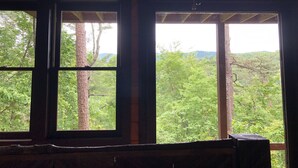A room with two windows, wooden beams, and a view of a forested landscape. - Fantastic Mountain Views Plus Hot Tub and Fire Pit!! (Blue Ridge)